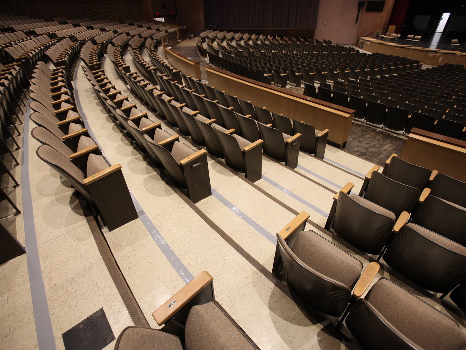 Tiered auditorium seating, with gray tape covering newly laid loop runs along each step